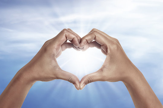 heart shaped hand with blue sky background