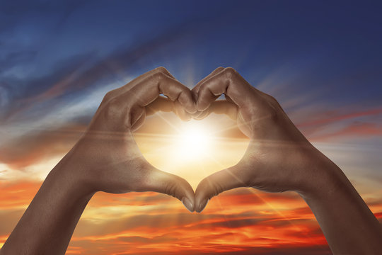 Heart shaped hand with sunrise