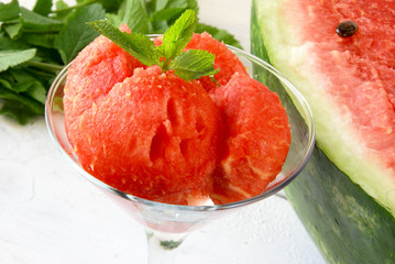 Watermelon balls in glass with mint and star of watermelon on a wooden table