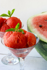 Watermelon balls in glass with mint and star of watermelon on a wooden table