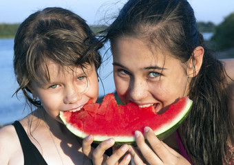 Two girl eating a slice of watermelon