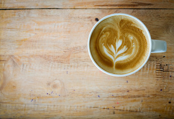 Coffee in white cup on wood table in coffee shop.