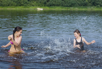 Fototapeta premium young girl gets a big splash of water on a hot summer day
