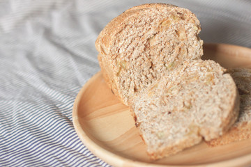 whole wheat bread is sliced on the wooden plate