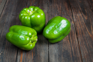 green paprika on wood background. close up