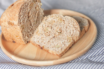 whole wheat bread is sliced on the wooden plate
