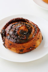 Sweet bun with poppy seeds on white