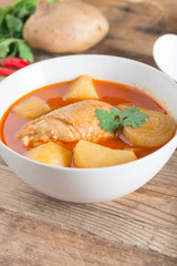 Chicken mussaman curry in white bowl.