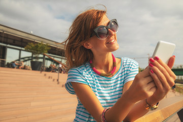Girl using cellphone outdoors.
