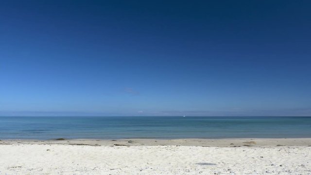 Beach scene without people. Peaceful and relaxing. White sand and blue sky. Clip contains beach, water, background, calm sea, smooth water, peaceful, relaxing, beautiful, blue, white	
