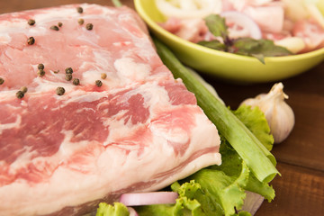 Raw meat on the plate. Wooden background. Close-up