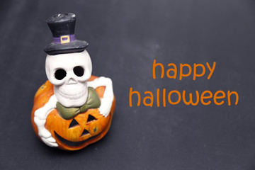 Halloween skeleton on pumpkin, dark wooden background