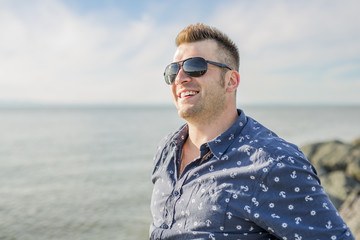 Portrait of mid adult man in blue shirt side beach