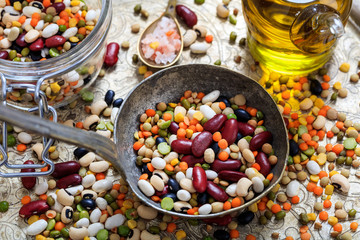 Old metallic spoon and mixed legumes