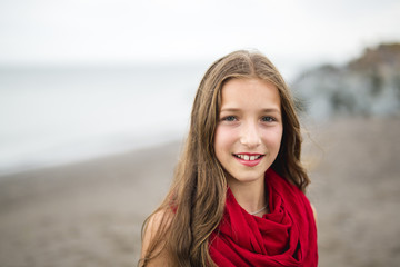 Girl enjoying the rain and having fun outside on the beach  a gray rainy