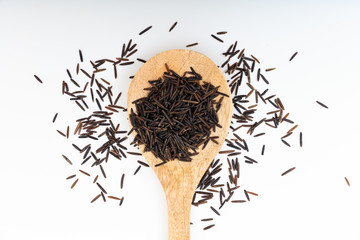 Raw wild rice in a wooden spoon