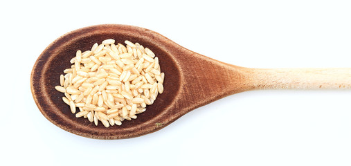 Raw unrefined rice in a wooden spoon