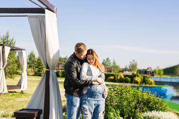 Happy couple awaiting baby, cute pregnant woman with husband enjoying spring weather, love concept