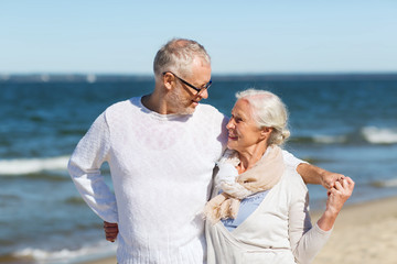 Fototapeta na wymiar happy senior couple hugging on summer beach