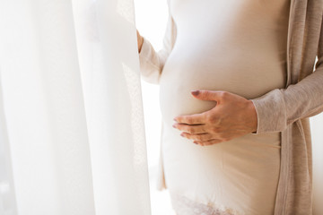 close up of pregnant woman belly and hands