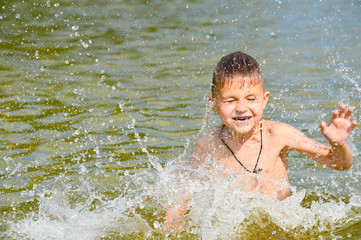 Obraz premium Boy swims in the lake water with a green tint.