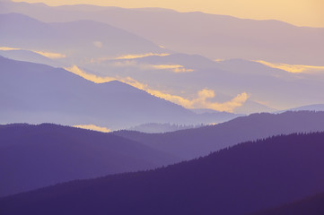 silhouettes of mountain peaks in the fog down in the evening. Roerich minimalism

