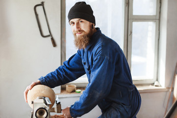 Fototapeta na wymiar A man working with woodcarving instruments