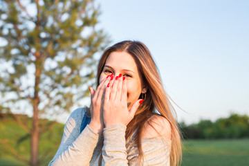 Surprised young woman with hands over her mouth outdoor