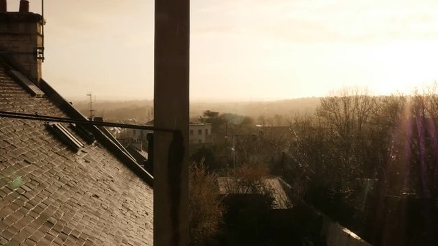 Sunset over northern Europe city while rain is falling in slow motion 1080p FullHD footage - Strange sun shining while raindrops are falling 1920X1080 slow-mo video 