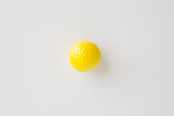 close up of yellow golf ball over white background