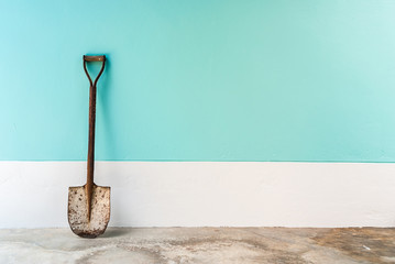 old shovel with mint, cyan pastel cement wall background