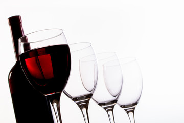 Weinflasche, Weingläser leer und mit Rotwein gefüllt in Reihe und Untersicht, Nahaufnahme
