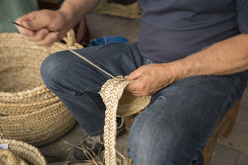 hand man weaving a wicker basket