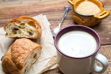 Czekoladowy croissant z kawą na drewnie