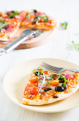 Pizza with salami, cherry tomatoes and arugula