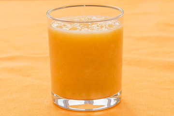 Orange smoothie on orange background