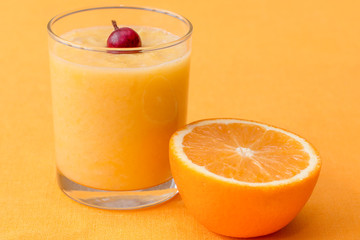 Orange smoothie with gooseberry on orange background