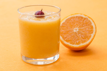 Orange smoothie with gooseberry on orange background