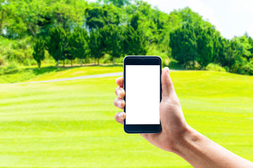 Hand using smartphone mobile in the vertical position, background blur of golf.