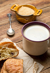 Czekoladowy croissant z kawą na drewnie