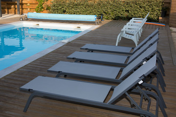 Architecture; beautiful garden with pool, four sunbeds view