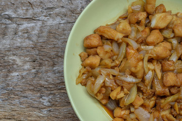 fish fillet fried with onions on wood background