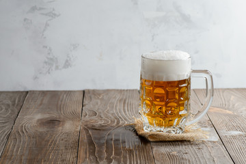 Glass of beer with foam on a wooden background