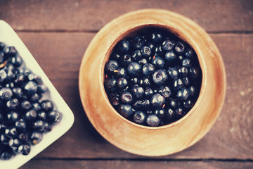 Wild blueberries in a wooden bowl and plate