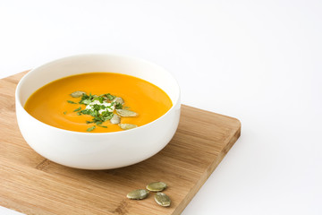 Pumpkin soup with cream and pumpkin seeds isolated on white background

