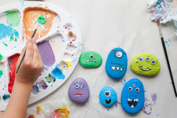 Child using paint for making stone monsters craft
