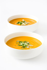 Pumpkin soup with cream and pumpkin seeds isolated on white background

