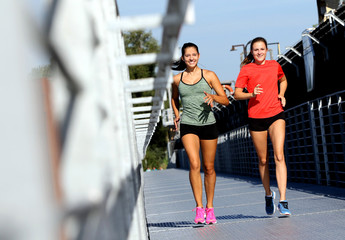 Obraz premium Freundinnen beim Joggen auf einer Brücke/Steg im Sommer