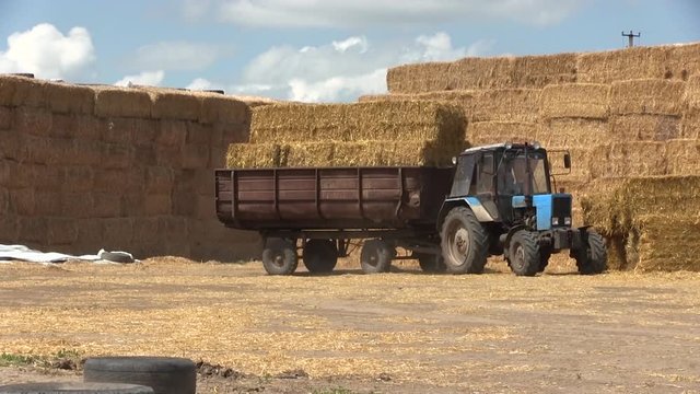 Tractor And Trailer With Hay Bales In Rural Landscape