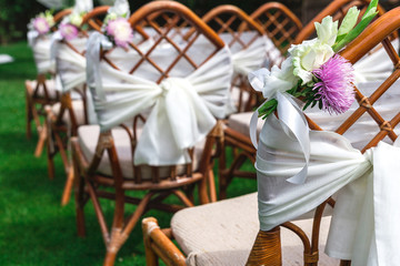 Wedding chairs decorated with flowers. Close up.